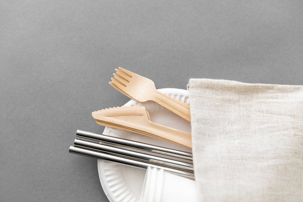 wooden forks, knives and paper cups on plate - Photo, image