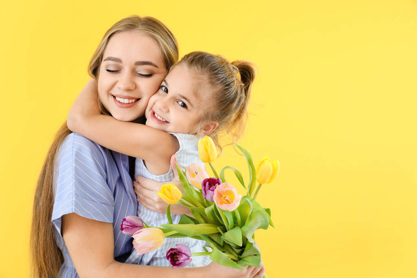kleines Mädchen grüßt ihre Mutter auf farbigem Hintergrund - Foto, Bild