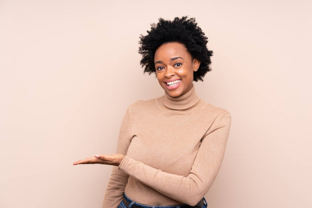Африканська американка через ізольоване тло представляє ідею, дивлячись посміхаючись до - Фото, зображення