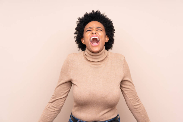 Afričanky americká žena přes izolované pozadí křičí dopředu s ústy široce otevřenými - Fotografie, Obrázek