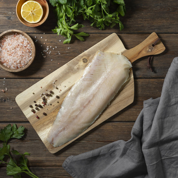 Lightly salted muksun fish on a wooden Board on a brown wooden table. Whole fillet of fish whitefish or muksun closeup. Top view with space for text - Φωτογραφία, εικόνα