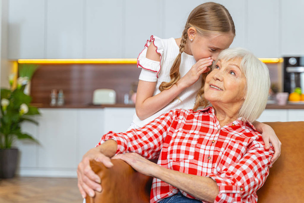 Granddaughter telling a secret to an elderly woman - Foto, Bild