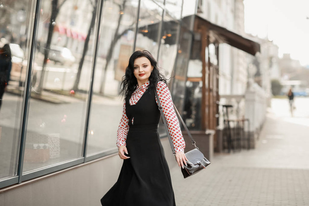 Beautiful woman in fashionable clothes walking through the streets of the city - Fotografie, Obrázek