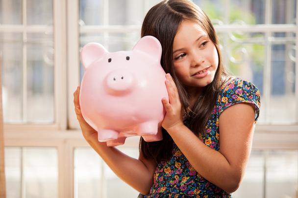Little girl with a piggy-bank - Фото, зображення