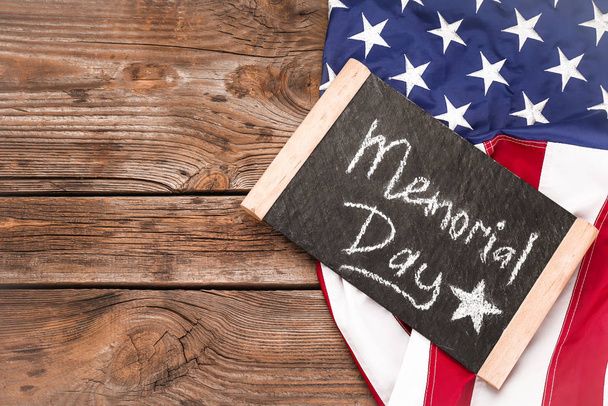 Pizarra con texto MEMORIAL DAY y bandera de EE.UU. sobre fondo de madera
 - Foto, imagen