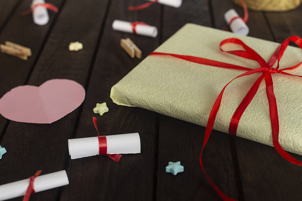 Fond romantique. Coffret cadeau avec souhaits roulés paquet cadeau en papier sur carton en bois
. - Photo, image