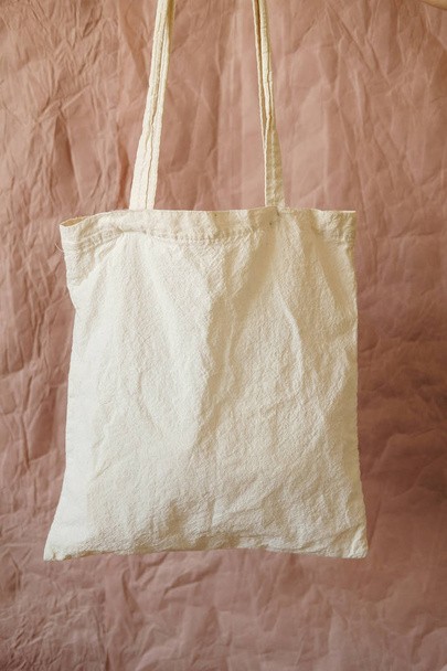 Eko pamuklu kumaş çanta çantası. Tekrar kullanılabilir ürün torbası. Marketten bedava plastik alışveriş poşeti. Sıfır atık daha az plastik yaşam tarzı kavramı kullanın. Kahverengi arkaplanda izole edilmiş boş şablonu düzenle - Fotoğraf, Görsel