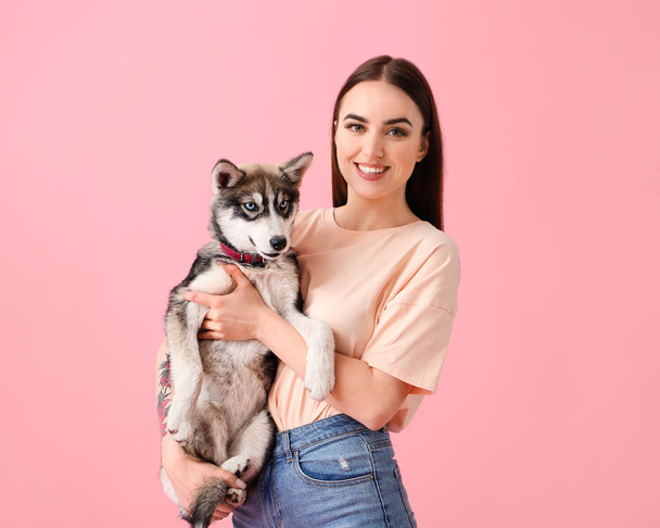 Carino donna con divertente husky cucciolo su sfondo di colore
 - Foto, immagini