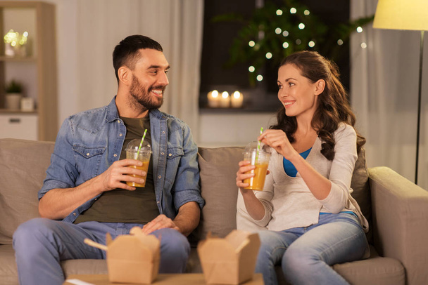 happy couple drinking takeaway juice at home - Zdjęcie, obraz