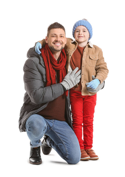 Cute little boy with father in winter clothes on white background - Foto, immagini