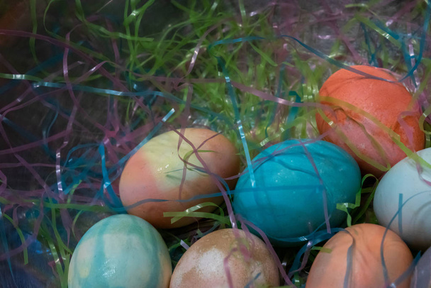 ovos de páscoa tingidos coloridos reunidos em uma mesa com grama de Páscoa
 - Foto, Imagem