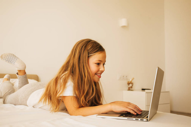 Young pretty girl using laptop at home  - Fotó, kép