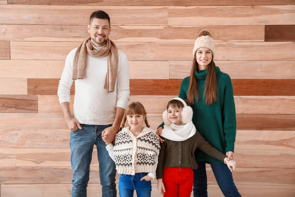 Happy family in winter clothes on wooden background - Photo, Image