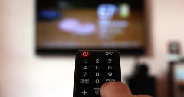 Muž sledující televizi a měnící se kanály s černou televizí dálkové ovládání. Close Up Shot - rozlišení Dci 4k - Záběry, video