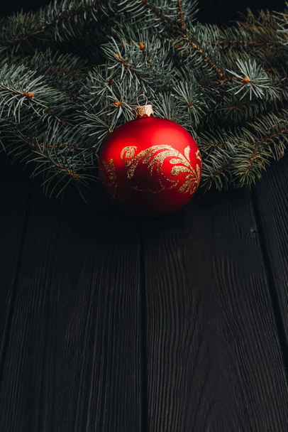 Christmas New Year decoration composition. Top view of fur-tree branches and balls frame on wooden background with place for your text. close up. - Photo, Image