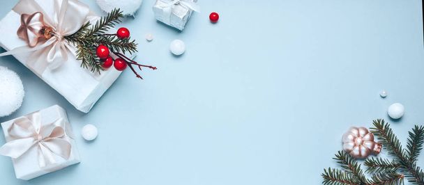 Composição de férias de Natal, caixas de presente brancas e brinquedos de Natal dourados em um fundo azul claro. Minimalismo, deitado plano. Espaço de cópia
 - Foto, Imagem