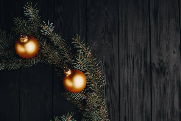 Vánoční nebo nový rok hračky dekorace zlaté koule a kožešiny strom větev rustikální na dřevěném pozadí, horní pohled, kopírovací prostor. - Fotografie, Obrázek
