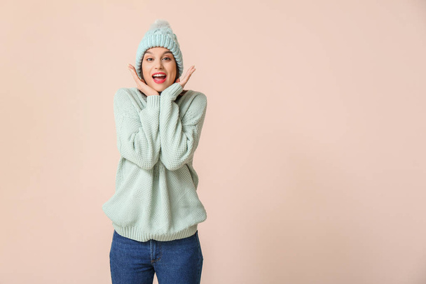 Happy young woman in winter clothes on light background - Photo, image