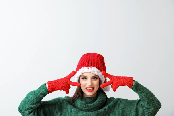 Gyönyörű fiatal nő Santa kalap a fény háttér - Fotó, kép