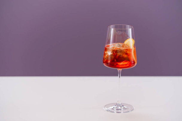 vaso de aperol spritz cóctel con hielo y naranja sobre fondo claro
 - Foto, Imagen