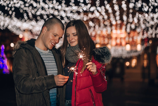 Couple avec des étincelles dans la nuit de la ville d'hiver
 - Photo, image
