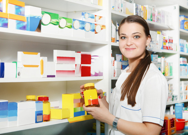 Farmacéutico sosteniendo tabletas en frasco en la farmacia
 - Foto, imagen