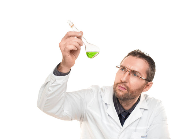 Medico maschio guardando attentamente in liquido verde In becher. Isolato su bianco
. - Foto, immagini