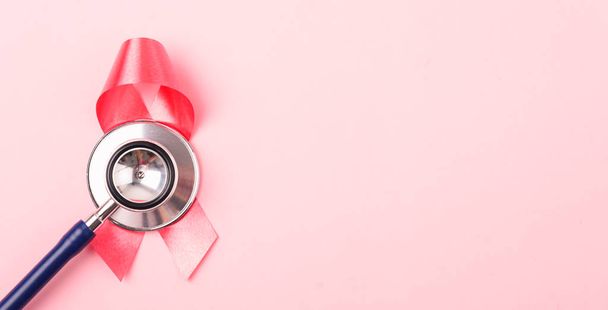 Breast Cancer Awareness Month Health concept, top view flat lay pink ribbon and stethoscope on pink background with copy space for your text - Fotó, kép