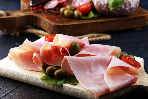 Bandeja de comida con delicioso salami, trozos de jamón crudo en rodajas
 - Foto, imagen