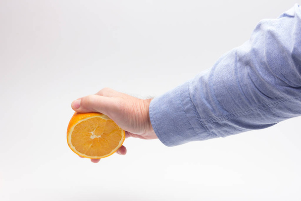 Portakal, yetişkin birinin elinde meyve suyu hazırlıyor. - Fotoğraf, Görsel