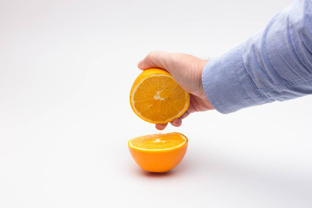 Arancione nelle mani di una persona adulta, preparare un succo
 - Foto, immagini