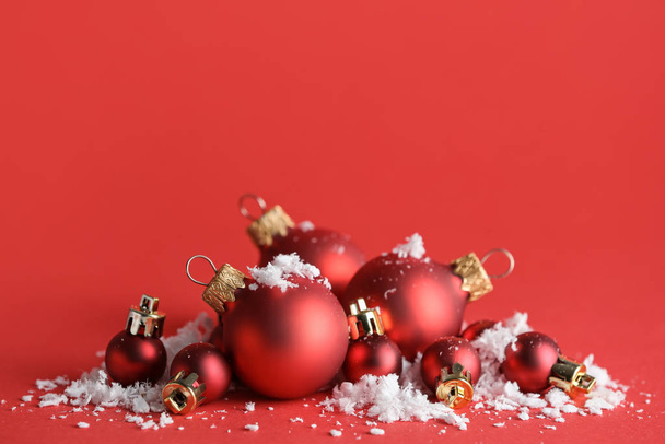 Mooie kerstballen met sneeuw op kleur achtergrond - Foto, afbeelding