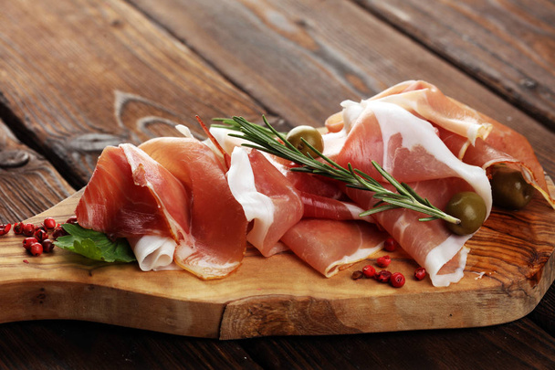 Italian prosciutto crudo or jamon with rosemary. Raw ham with sp - Photo, Image