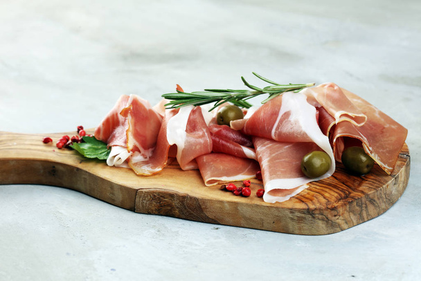 Italian prosciutto crudo or jamon with rosemary. Raw ham with sp - Foto, Imagen