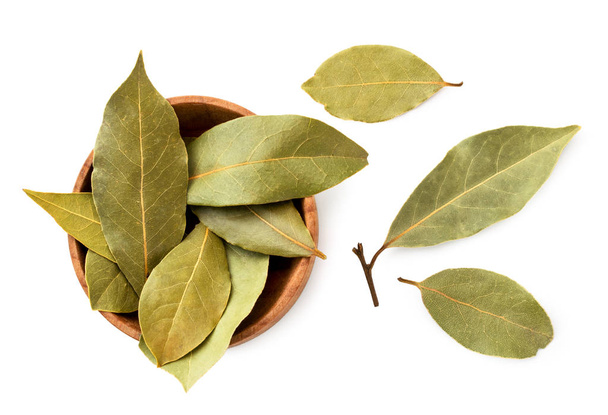 Dried bay leaf in a wooden plate on a white background. The view of top. - Photo, Image