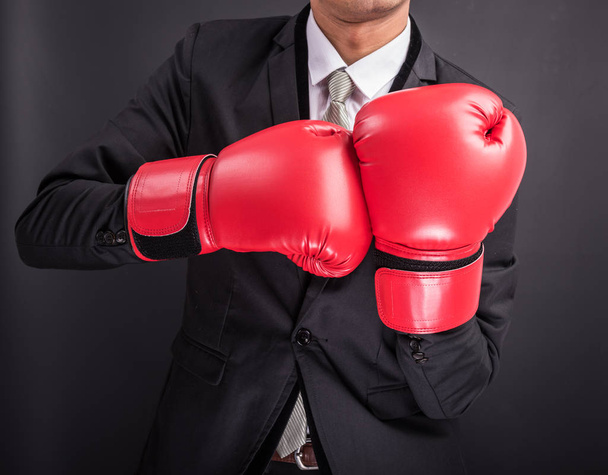 Young businessman with boxing gloves isolated on black background - Foto, Imagen