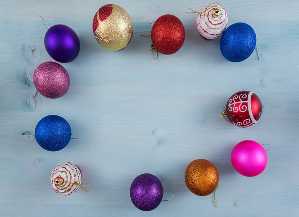 Christmas background with Christmas tree colored toys, balls sprinkled with sequins on a flat surface with a place for the inscription copy space , top view, blue substrate - 写真・画像