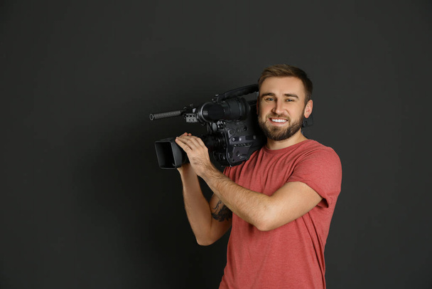 Operator with professional video camera on black background - Zdjęcie, obraz