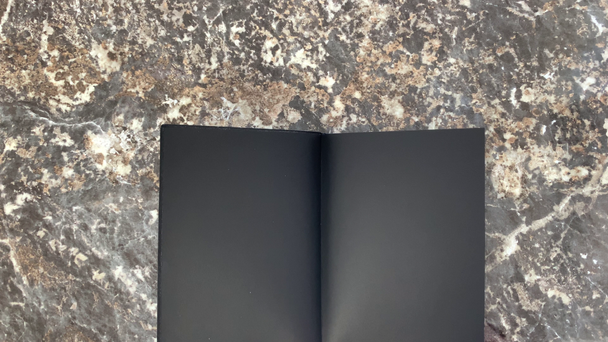Incrível cósmico belo diário preto em um fundo de mármore preto, abre e você pode fazer anotações. A rolar páginas. Vista superior
. - Filmagem, Vídeo