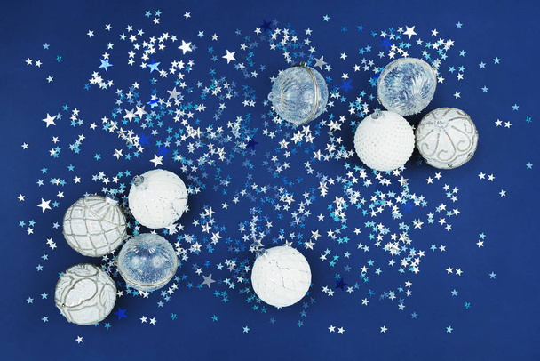 Χριστουγεννιάτικα λευκά μπιχλιμπίδια συλλογή σε μπλε φόντο glitter - Φωτογραφία, εικόνα