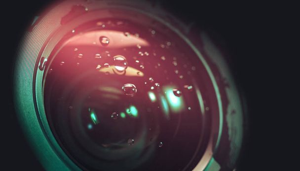 Sluiten van mooie Camera lens van druppelwater, roze licht op een zwarte achtergrond patroon voor het ontwerp. Macro fotografie zicht - Foto, afbeelding