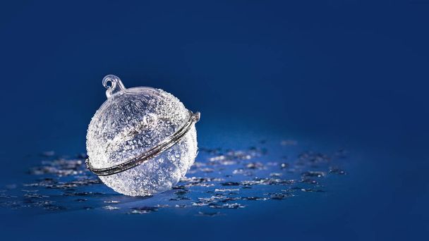 Christmas white crystal bauble on blue glitter background - Zdjęcie, obraz