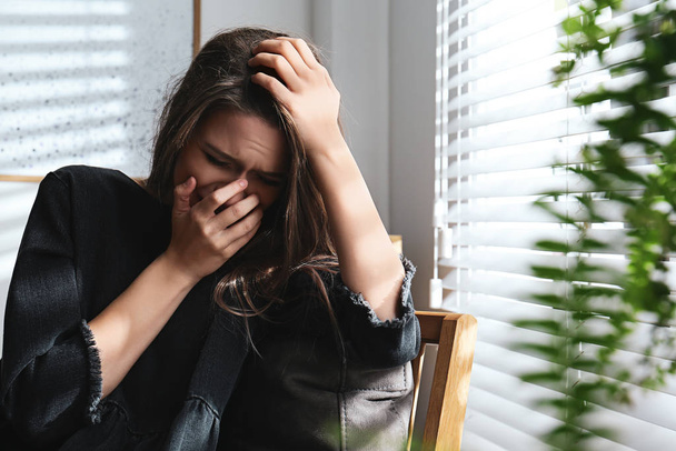 Abused young woman crying indoors. Domestic violence concept - Valokuva, kuva