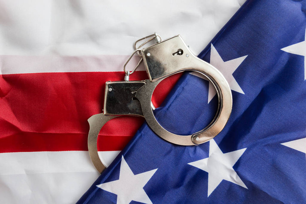 Handcuffs on the American flag, a concept of crime detection and crime rate in the United States - Fotoğraf, Görsel
