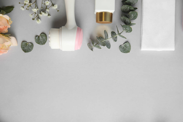 Flat lay composition with face cleansing brush on light grey background. Cosmetic accessory - Foto, afbeelding