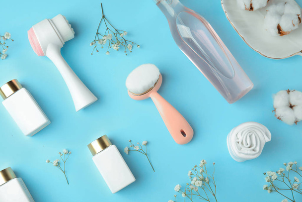 Flat lay composition with face cleansing brushes on light blue background. Cosmetic accessories - Fotó, kép