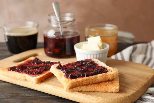 Composition with delicious toasts with jam on wood board, close  - Фото, изображение