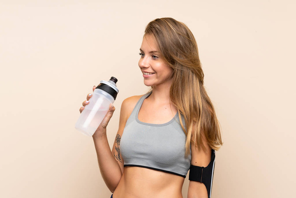 Giovane ragazza sportiva bionda su sfondo isolato con bottiglia d'acqua sportiva
 - Foto, immagini