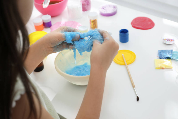 Little girl making DIY slime toy at table, closeup - Foto, afbeelding