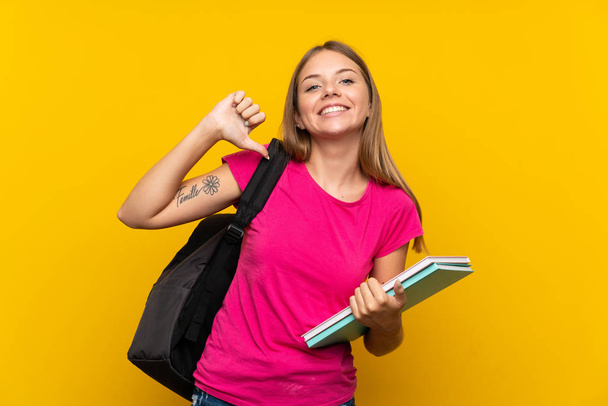 Young student girl over isolated yellow background proud and self-satisfied - Photo, image